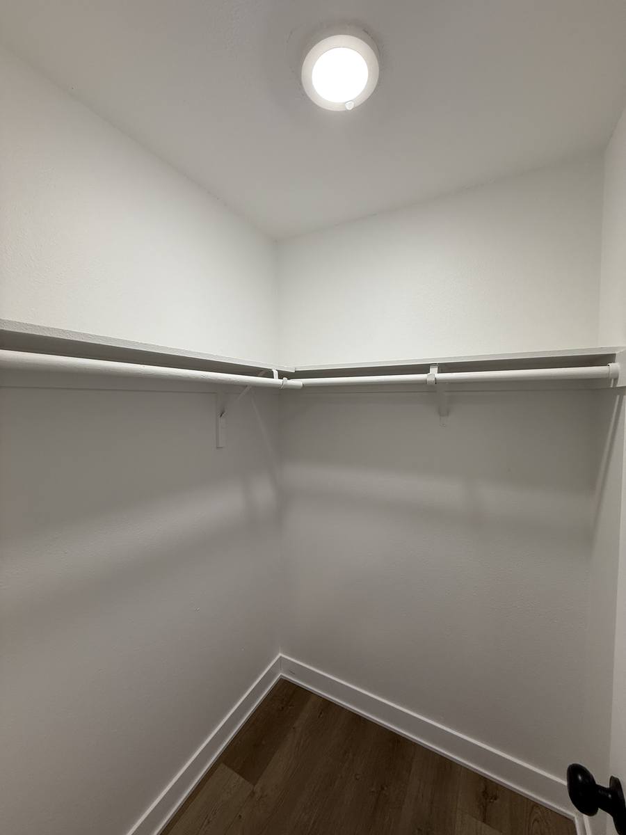 A walk-in closet with wire shelving running along two walls.